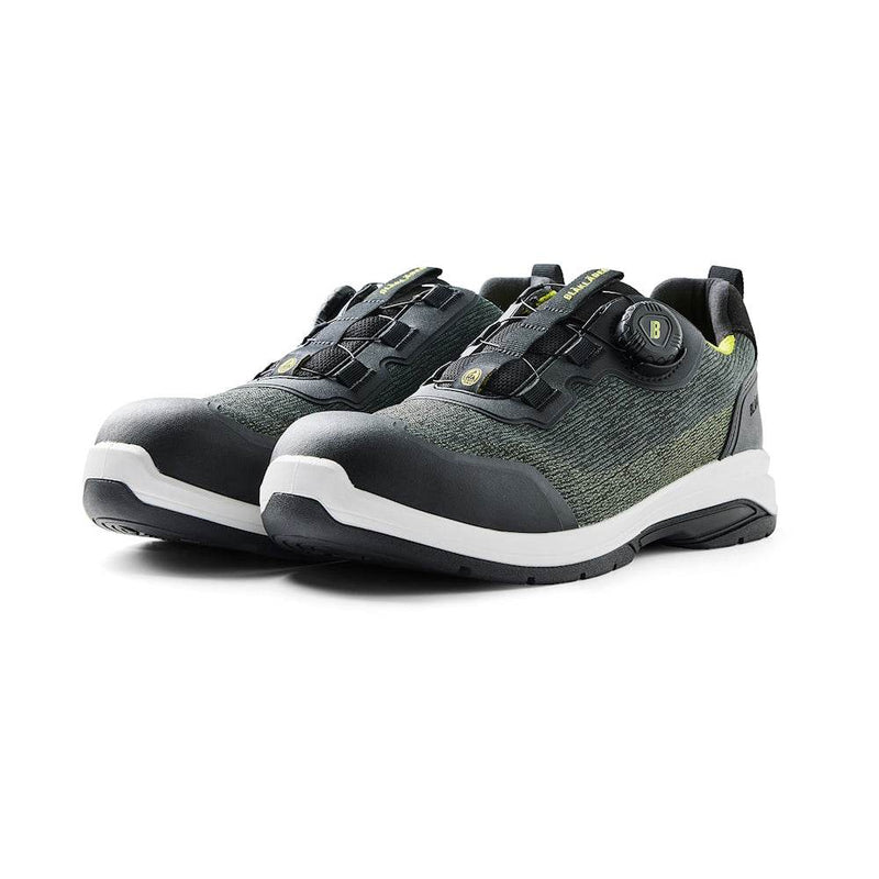 Pair of black and green shoes with white soles on a white background