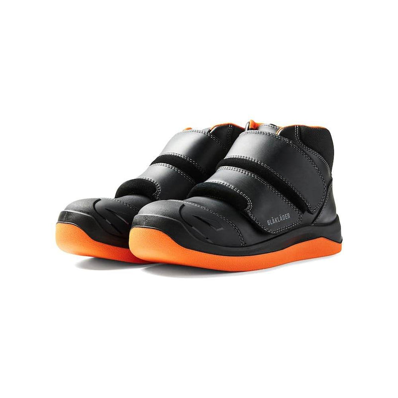 Black and orange shoes with velcro straps on a white background