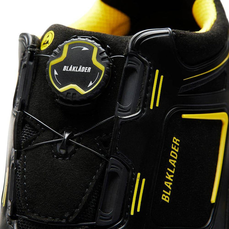Close-up of a black and yellow Blaklader work boot with branding details.