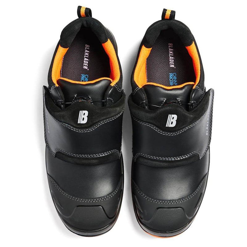 Pair of black safety shoes with orange accents on a white background