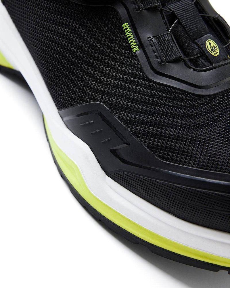 Close-up of a black athletic shoe with white sole and yellow accents on a white background