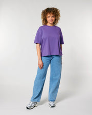 Person wearing a purple shirt and blue jeans on a white background