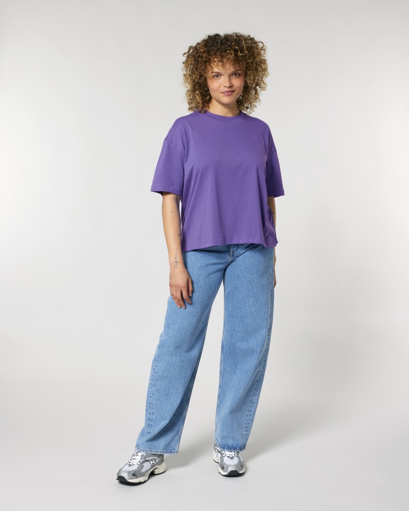 Person wearing a purple shirt and blue jeans on a white background