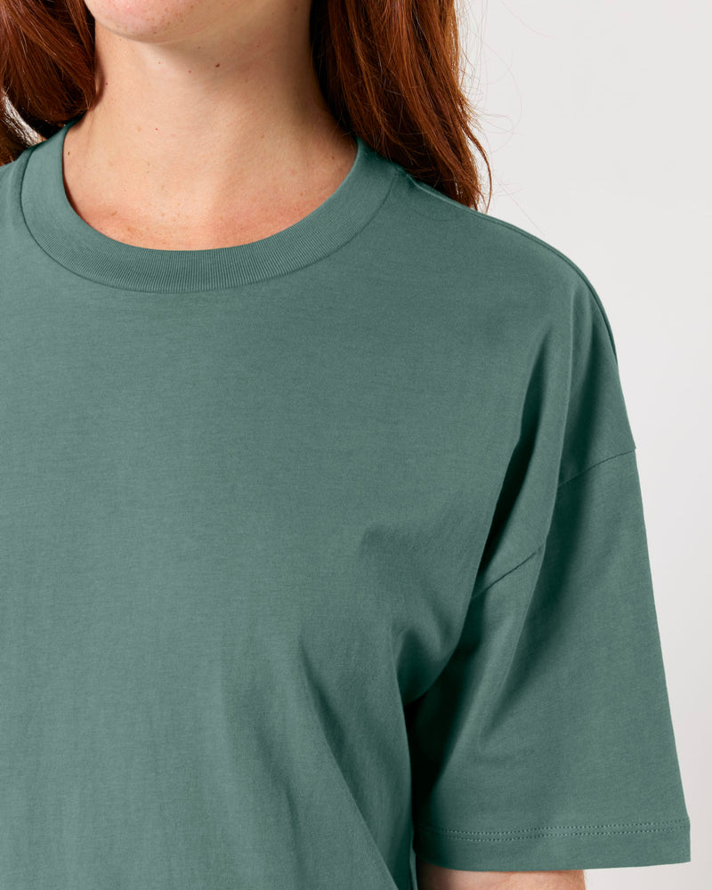 Person wearing a plain green t-shirt against a neutral background