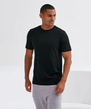 Man wearing a black work t-shirt and gray pants on a white background