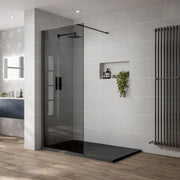 Modern bathroom with a shower area featuring a glass door and black tray.
