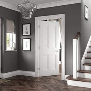 Staircase with a white door and gray walls in a home interior.