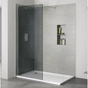 Modern shower enclosure with glass door and tiled wall in a bathroom setting.