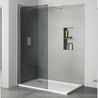 Modern shower enclosure with glass door and tiled wall in a bathroom setting.