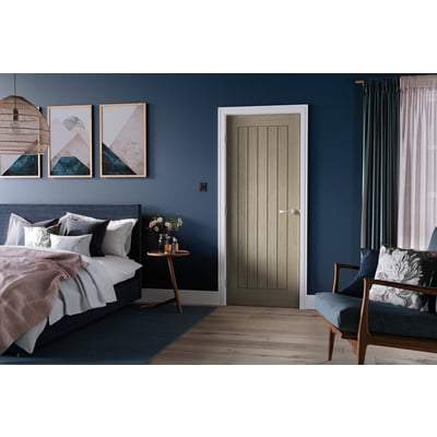 Modern bedroom with dark blue walls, a bed with white bedding, and a wooden door.