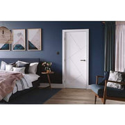 Modern bedroom with blue walls, a white door, and decorative elements.