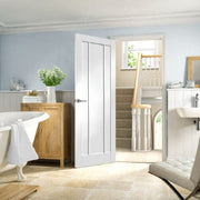 Modern interior with a white door, light blue walls, and wooden furniture.